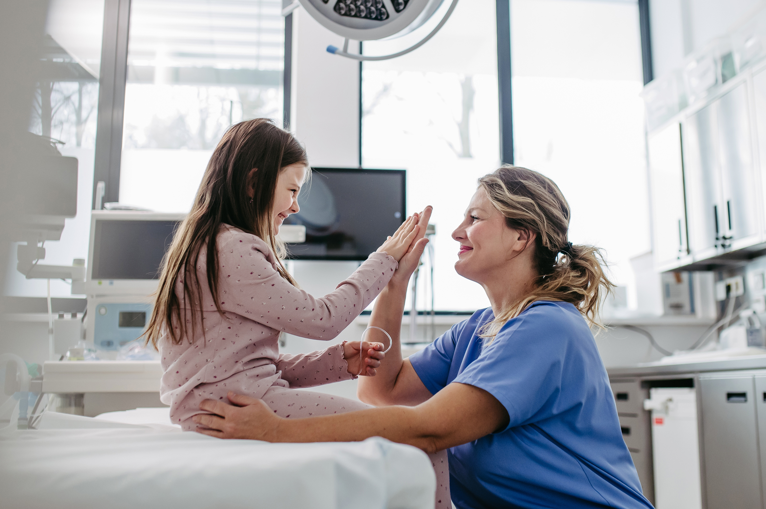 Young female patient high-fiving female nurse